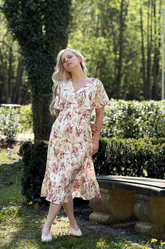 a lady in a pink floral printed silk dress